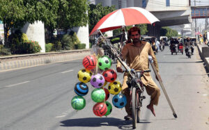 A disabled man sells balloons and plastic footballs on his bicycle, striving to earn a living for his children in the provincial city.