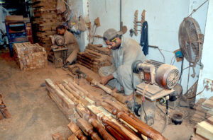 A carpenter crafting wooden stair railings as part of his daily routine at his workshop