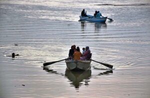 People are enjoying riding on boats in the River Ravi during the evening time in the Provincial Capital.