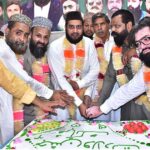 People cutting cake to celebrate Eid Milad-un-Nabi (SAWW) organized by Pakistan Sunni Tehreek