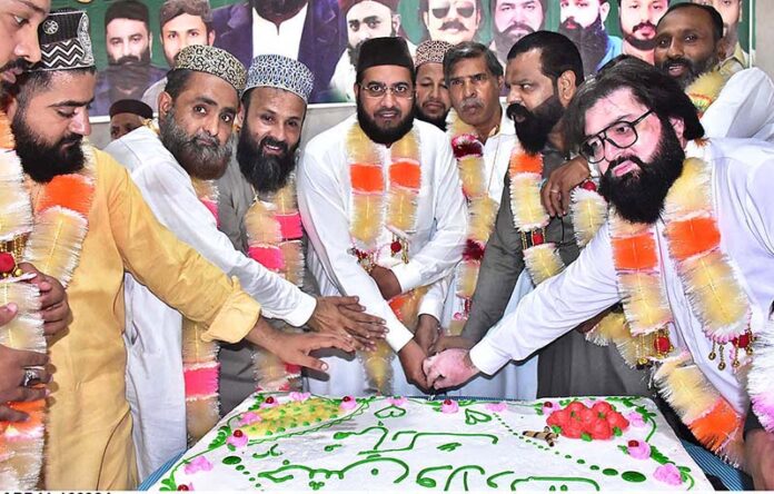 People cutting cake to celebrate Eid Milad-un-Nabi (SAWW) organized by Pakistan Sunni Tehreek