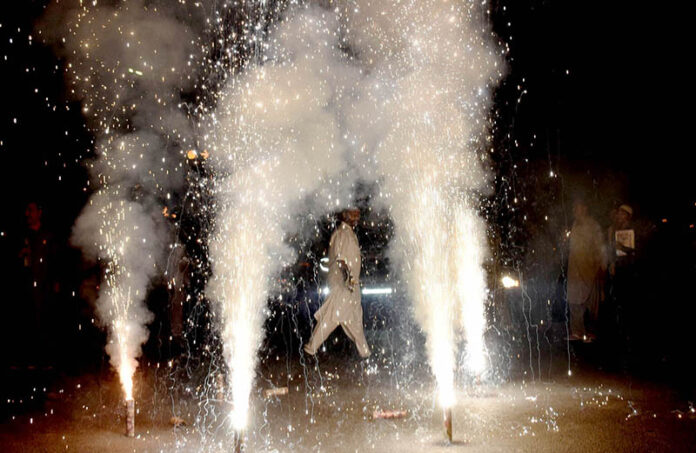Participants light fireworks during the Mashal Bardar Jaloos (torch march) to celebrate Eid-e-Milad-un-Nabi