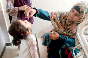 A health worker administering Polio Vaccine Drop to a girl during Polio Vaccination Door-to Door Campaign in the city.