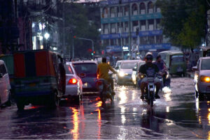 Vehicles passing through rain water accumulated on the road after rain at Mall Road.