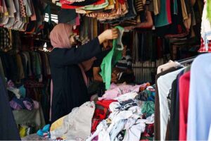 A woman selecting to stock up on second-hand warm clothes and other stuff from vendor at the weekly Bazaar as the capital city prepares for the onset of winter.