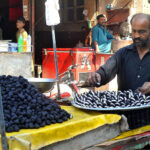 A vendor is busy displaying seasonal fruit Singhara to attract customers at his hand cart setup