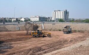 Machinery is being used for leveling the ground to prepare a green area along the road near Kakpul.