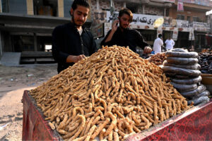 Vendor arranging and displaying traditional sweets item at roadside in the Federal Capital