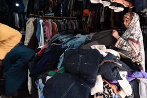 A woman selecting to stock up on second-hand warm clothes and other stuff from vendor at the weekly Bazaar as the capital city prepares for the onset of winter.