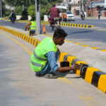 PHA staffers busy painting the road divider near Pul Moj Darya as part of the city's beautification efforts