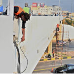 Laborers hard at work painting a flyover bridge, adding a fresh touch to the Federal Capital infrastructure