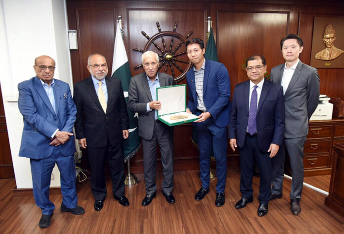 Federal Minister for Maritime Affairs Qaiser Ahmed Sheikh is presenting souvenir to representative of Malaysian Company