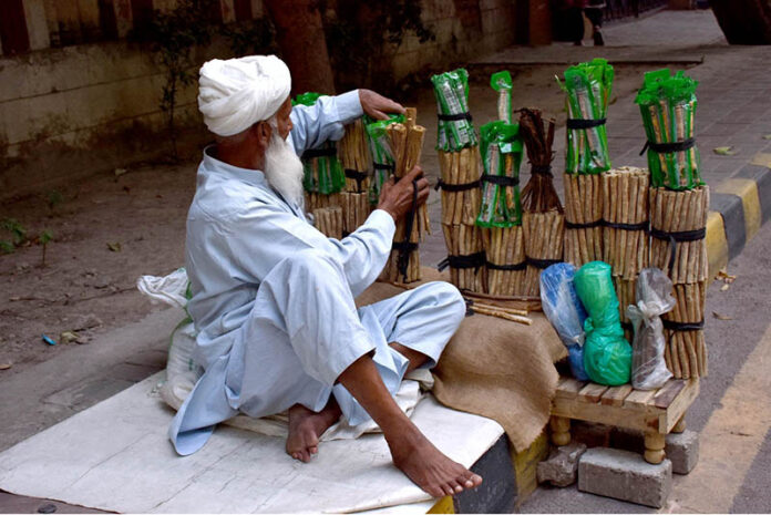 An elder vendor is displaying traditional toothbrush (Miswak) at Zahoor Ali Road