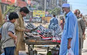 Customers gather, inspecting fresh fish for buying at a vendor’s stall at Khanna Pul in twin cities