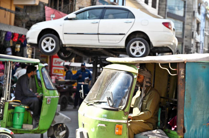 A traffic warden uses a lifter to remove an illegally parked car, clearing obstacles to ensure a smooth traffic flow and prevent disruptions for commuters