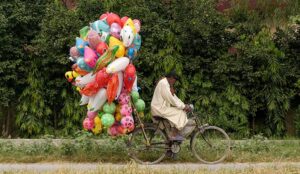 A vendor carrying colorful balloons on his bicycle for selling at Lehtrar Road neighbourhood in the Federal Capital