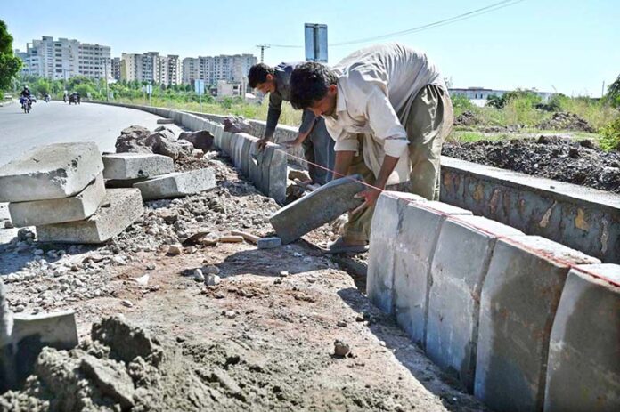 Labourers busy in fixing cemented blocks along Club Road in Federal Capital