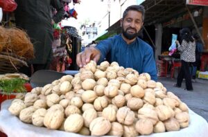 A vendor selling walnuts at his roadside stall, getting ready for the day's business in the Federal Capital.