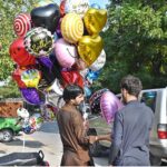A customer purchasing balloon from a street vendor at Jinnah Super Market in the Federal Capital