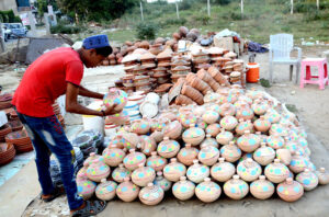 Shopkeeper display pottery to attract customers at his roadside setups.
