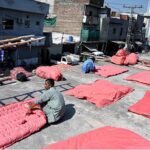 Workers are busy stitching Quilts at their workplace as demand increases in the winter season