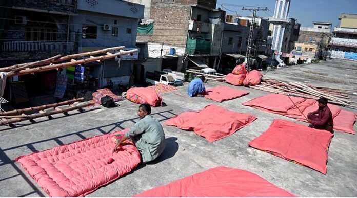 Workers are busy stitching Quilts at their workplace as demand increases in the winter season