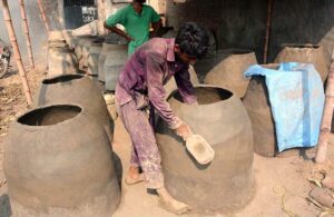 A potter busy in preparing traditional clay oven (tandoor) at his workplace.