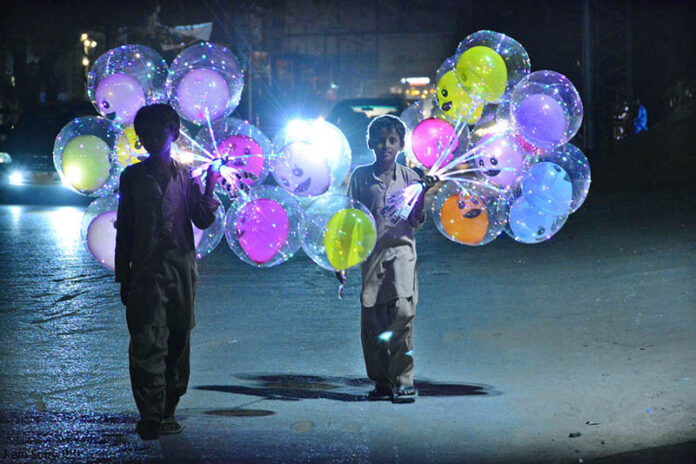 Street vendors displaying led light balloons to attract the customers at Latifabad
