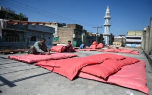 Workers are busy stitching Quilts at their workplace as demand increases in the winter season