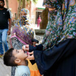 A female health worker administers polio drops to children during a vaccination drive aimed at eradicating polio in Pakistan