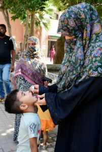 A female health worker administers polio drops to children during a vaccination drive aimed at eradicating polio in Pakistan