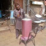 A painter busy in painting a geyser at his workplace as demand increased during winter season