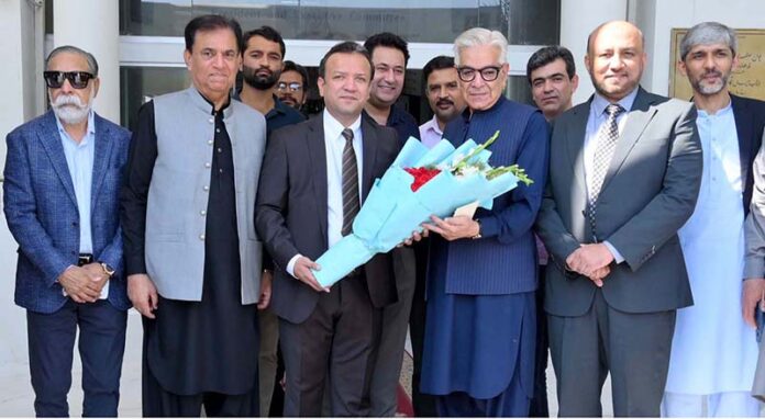 The newly elected President of the Chamber of Commerce Ikramul Haque is presenting a bouquet to Defense Minister Khawaja Muhammad Asif during his visit to SCCI