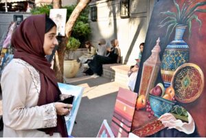 During the exhibition of paintings organized by Knowledge Art Academy and Fortnight School System at the historic Wazir Khan Mosque, visitors are admiring the works of art on display.