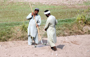 Farmers plowing the field by hand, using traditional methods to prepare for the new crop season and preserve their agricultural heritage on the outskirts area in the city.