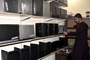 Shopkeeper displaying Laptop to attract costumers at Hall Road.