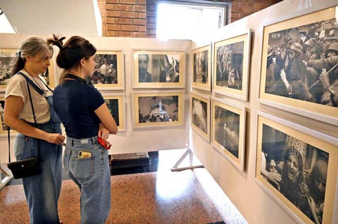 Foreigner women keenly viewing photos during an exhibition at PNCA on the occasion of Kashmir Black Day