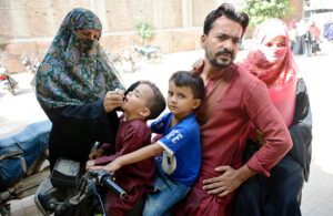 A female health worker administers polio drops to children during a vaccination drive aimed at eradicating polio in Pakistan