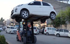 A traffic lifter tows away a wrongly parked car at Club Chowk, enforcing parking regulations to ease congestion for smooth traffic flow in the city.