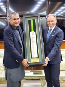 Interior Minister Mohsin Naqvi being presented an Australian Cricket team's autographed bat by the Australian High Commissioner Neil Hawkins.
