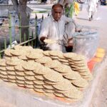 Vendor displaying and selling pigeons food to attract customers