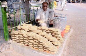 Vendor displaying and selling pigeons food to attract customers