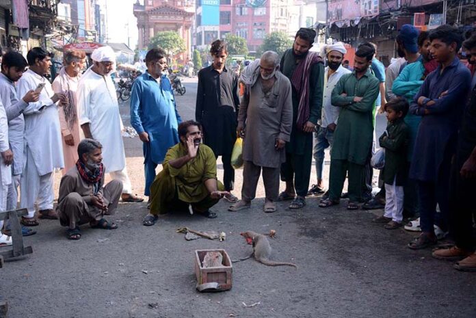 A juggler performing tricks to earn his livelihood at roadside