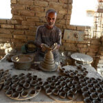 An artisan busy preparing traditional clay-made oil lamp for use upcoming Hindu festival Dewali at his workplace in kumharpara