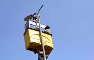 Municipal Corporation worker fixing street light without safety gloves at Jail Road.