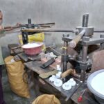 A man busy in making electric bulb holders on his setup