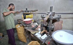 A man busy in making electric bulb holders on his setup