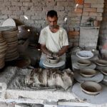 Craftsmen busy in preparing clay made pitchers at their workplace at Kumharpara