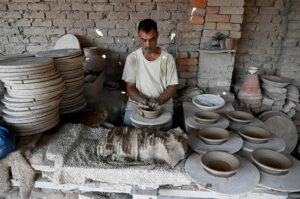 Craftsmen busy in preparing clay made pitchers at their workplace at Kumharpara
