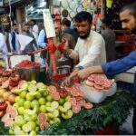 A vendor extracting pomegranate and grapefruit juices for customers at Qissa Khawani Bazaar